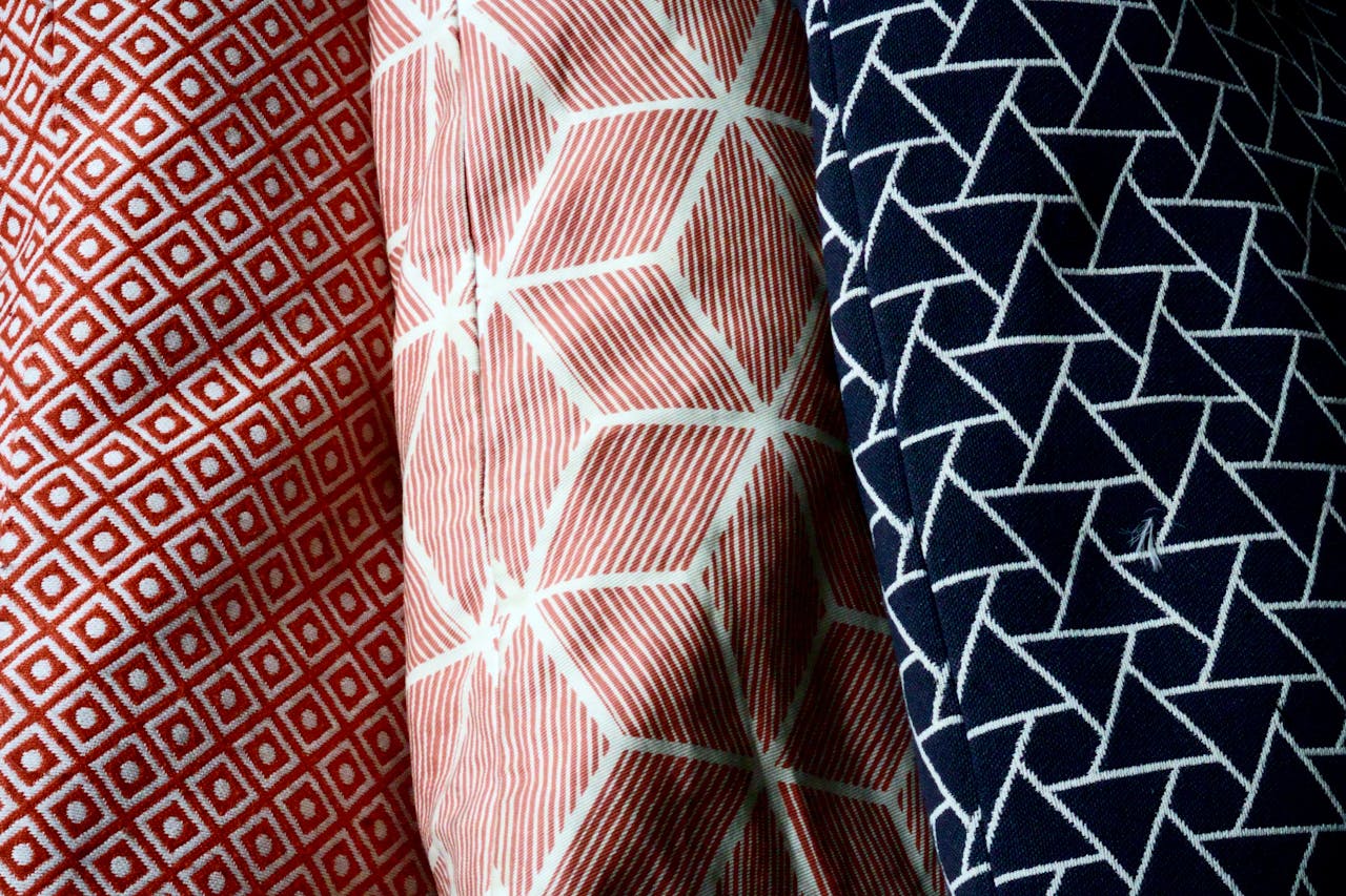 Detailed macro shot of colorful geometric patterned fabrics showcasing intricate textile designs.