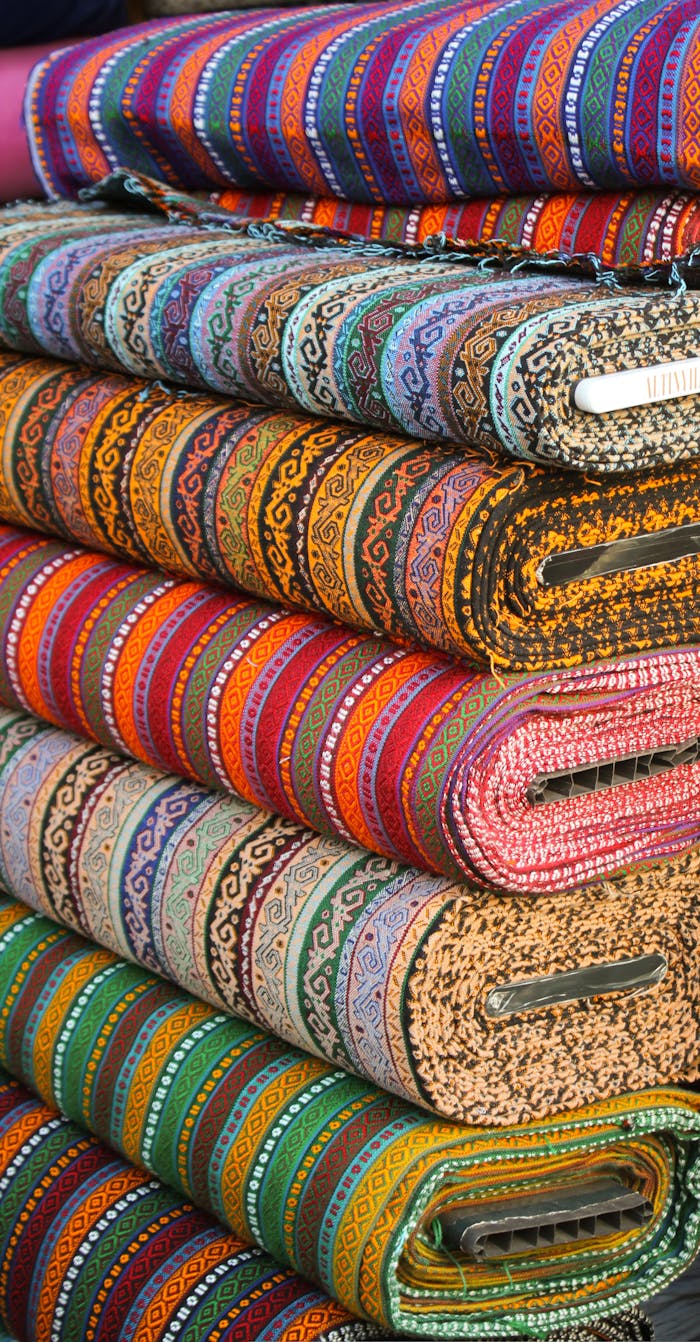 services-03 Vibrant stacked textiles with intricate ethnic patterns, showcasing diverse colors.